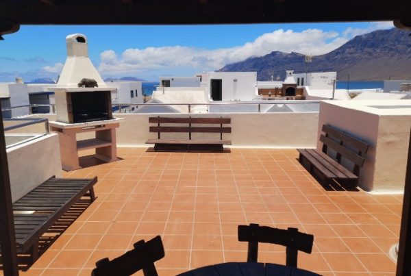 Amplia terraza soleada con vistas al mar en el hostal.