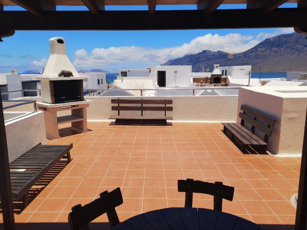 Amplia terraza soleada con vistas al mar en el hostal.