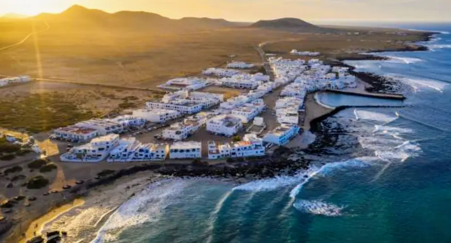 Vista panorámica de la carretera hacia Caleta de Famara, Lanzarote, con el Risco de Famara al fondo