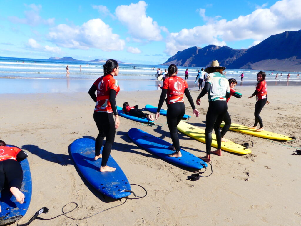 Surfista cabalgando una ola en la playa de Famara, Lanzarote